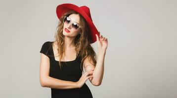 young beautiful stylish woman in black dress, red hat photo