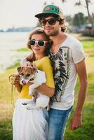 joven elegante hipster Pareja en amor participación un perro a el tropical parque foto