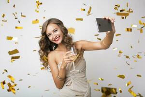 pretty woman celebrating party in golden confetti photo