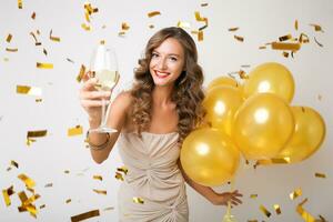 pretty woman celebrating party in golden confetti photo