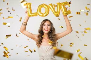 pretty woman celebrating party in golden confetti photo