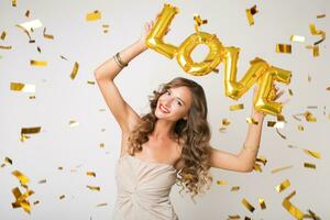 pretty woman celebrating party in golden confetti photo