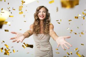 pretty woman celebrating party in golden confetti photo