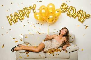 pretty woman celebrating party in golden confetti photo