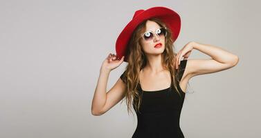 young beautiful stylish woman in black dress, red hat photo