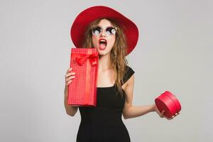 young beautiful woman holding presents, black dress, red hat photo