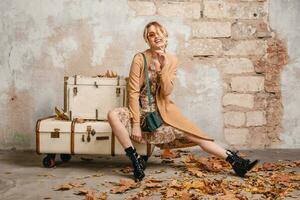 attractive stylish blonde woman in beige coat, spring autumn fashion trend photo