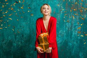attractive happy smiling woman in stylish red dress celebrating christmas photo