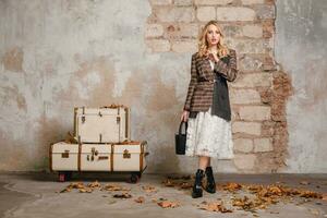 attractive stylish blonde woman in checkered jacket coat walking, autumn fashion trend photo