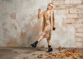 attractive stylish blonde woman in beige coat, spring autumn fashion trend photo