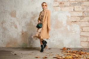 attractive stylish blonde woman in beige coat, spring autumn fashion trend photo