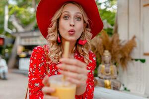 attractive stylish blond smiling woman in straw red hat and blouse summer fashion photo