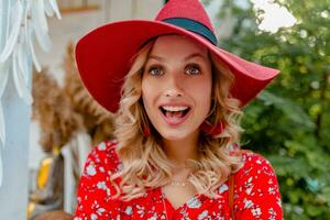 attractive stylish blond smiling woman in straw red hat and blouse summer fashion photo