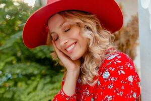 attractive stylish blond smiling woman in straw red hat and blouse summer fashion photo