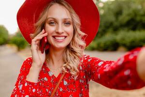 attractive stylish blond smiling woman in straw red hat and blouse summer fashion photo