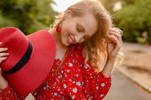 attractive stylish blond smiling woman in straw red hat and blouse summer fashion photo