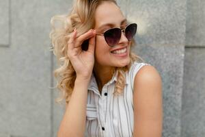 young attractive stylish woman with blond hairstyle walking in city photo