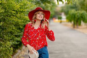 attractive stylish blond smiling woman in straw red hat and blouse summer fashion photo