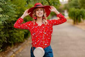 attractive stylish blond smiling woman in straw red hat and blouse summer fashion photo