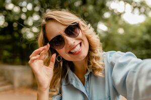 stylish blond woman walking in street park summer fashion photo