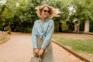 stylish blond woman walking in street park summer fashion photo