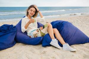 young stylish woman on beach drinking cocktail photo