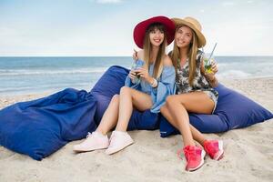 stylish pretty women on summer vacation on tropical beach photo