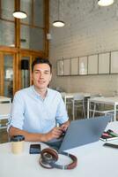 happy young confident man working on laptop photo