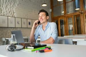 happy young confident man working on laptop photo