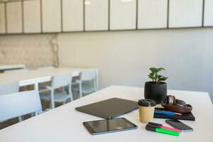 different office stationery arranged on white table in co-working office, freelancer workplace photo