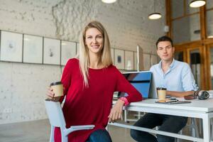 young man and woman working on laptop in open space co-working office room, busy freelancers photo