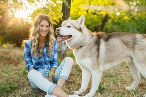 frio joven elegante bonito sonriente contento rubio mujer jugando con perro foto