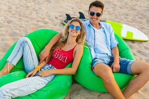 young smiling couple having fun on beach relaxing photo