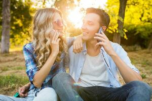 modern young stylish couple sitting in park photo