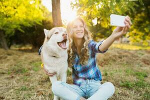 cute young stylish pretty smiling happy blond woman playing with dog photo