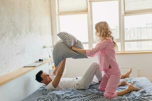 young couple having fun on bed in morning photo