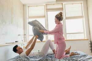 young couple having fun on bed in morning photo