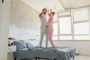 young couple having fun on bed in morning photo