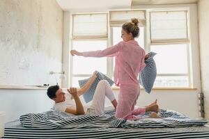 young couple having fun on bed in morning photo