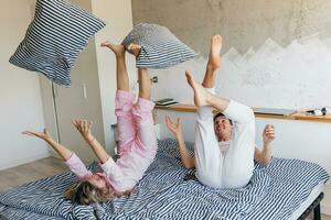 joven Pareja teniendo divertido en cama en Mañana foto