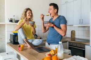 young attractive couple of man and woman cooking breakfast together in morning at kitchen photo