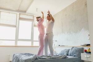 funny young couple having fun on bed in morning photo