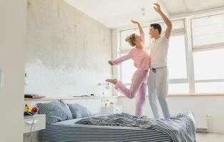 funny young couple having fun on bed in morning photo