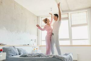 funny young couple having fun on bed in morning photo