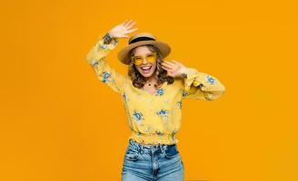 stylish happy smiling blond woman on vacation in straw on yellow background photo