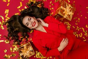 atractivo mujer celebrando Navidad en rojo antecedentes en papel picado foto