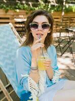 young attractive woman sitting in deck chair in summer fashion outfit photo