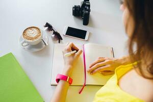 portrait of young pretty woman sitting at table, student learning photo