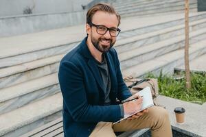 handsome busy bearded man working in park photo