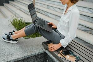 attractive business woman working outside on laptop photo